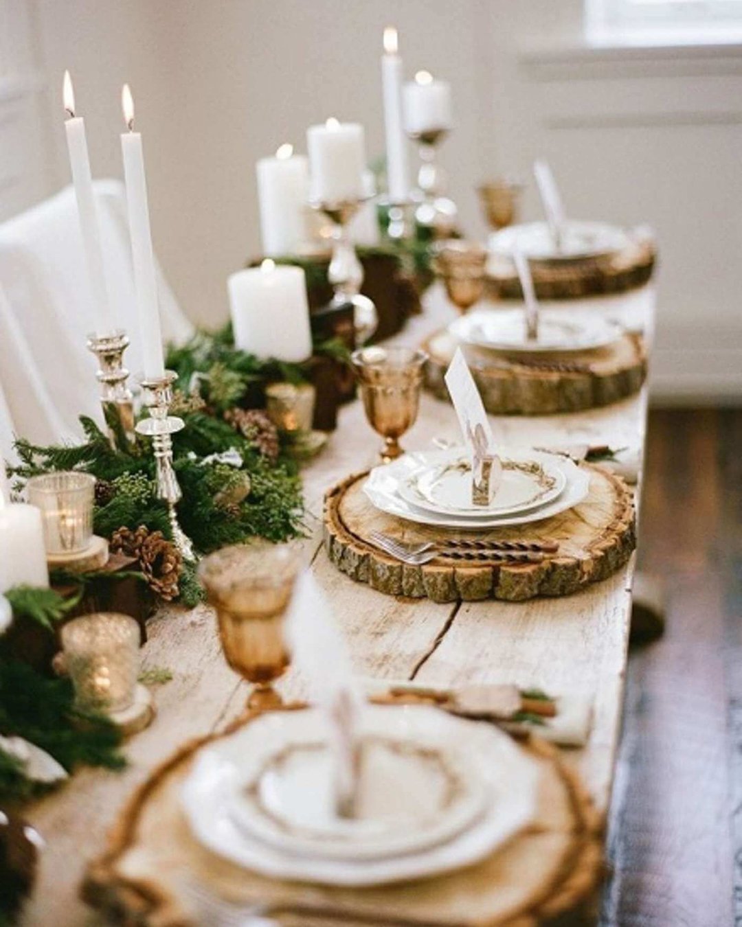 winter wedding decorations a long wooden table decorated with fir tree branches with cones and candles plates on wooden