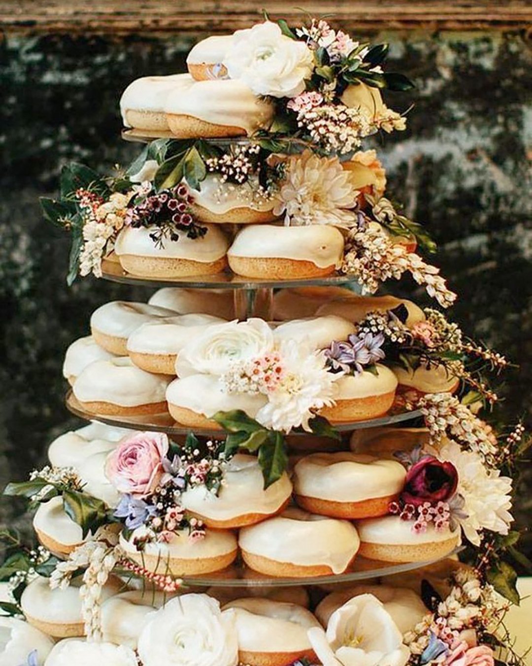 non traditional wedding dessert ideas white donuts tower with roses dahlias greenery paulbamford