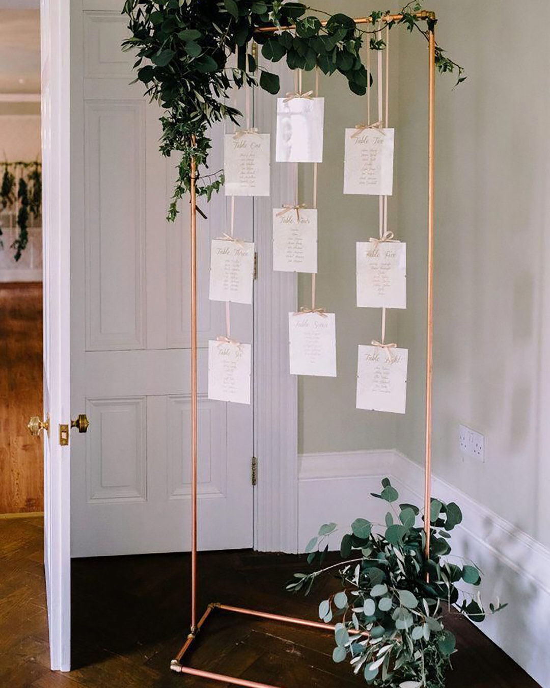 minimalist wedding decor metallic gold stand tableplan with greenery cluskey smith