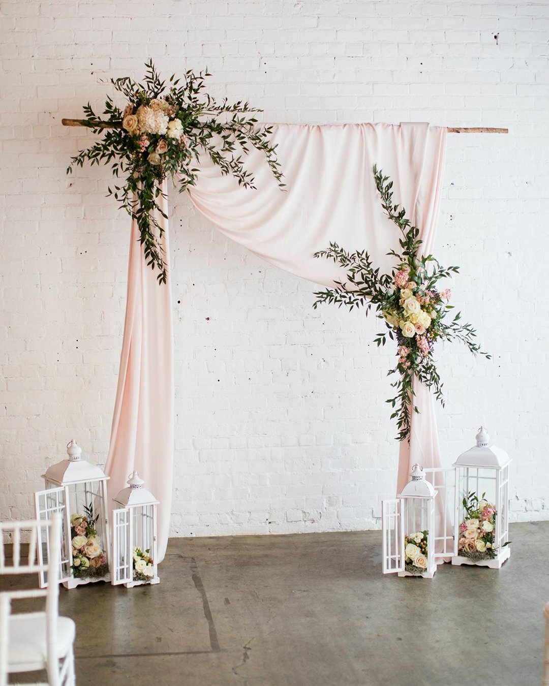 wedding ceremony decorations with pink draping cloth and flowers with greenery blossom vintage rentals