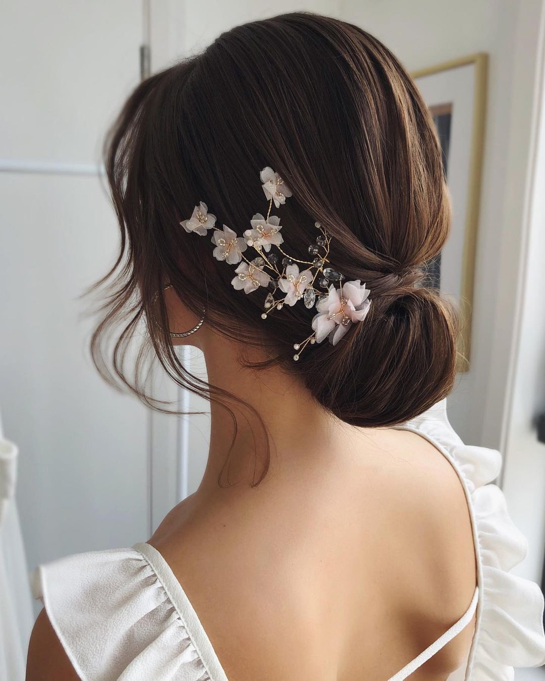 wedding hair trends low bun with flower pin caraclyne.bridal