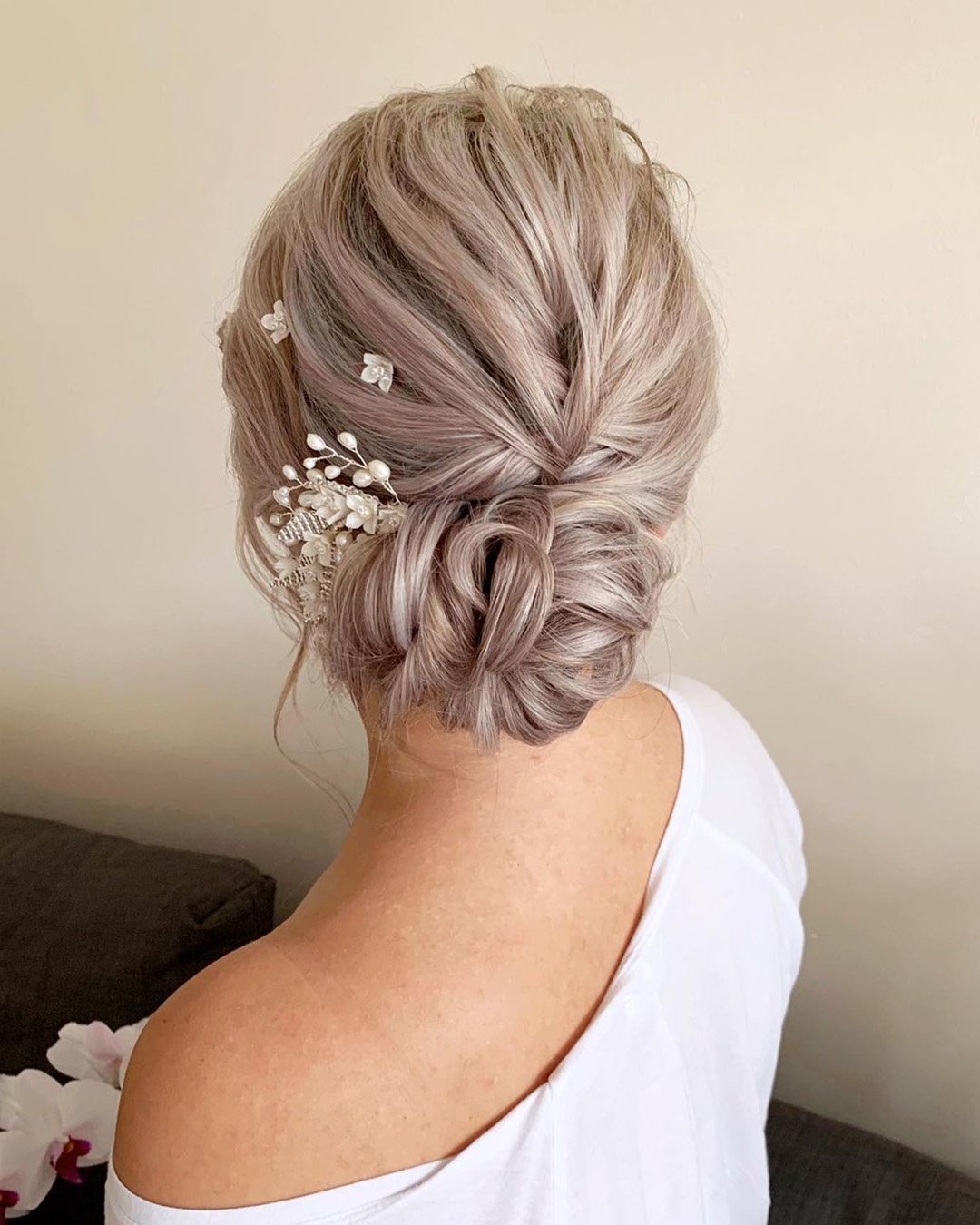 wedding hair trends low textured updo with gentle pins bridal_hairstylist