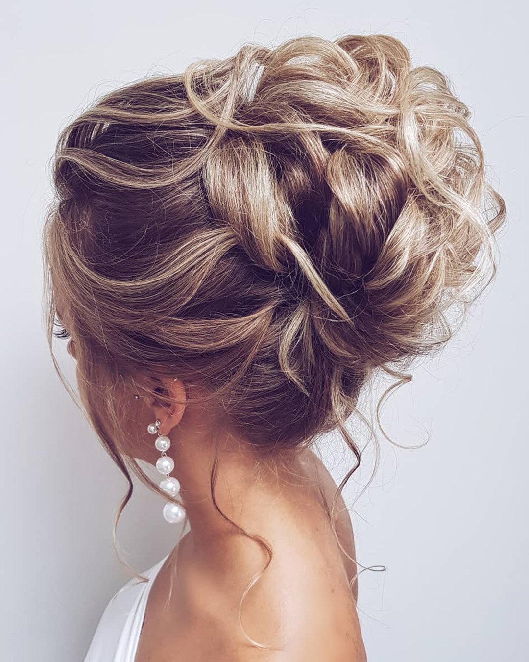 wedding hair trends messy high bun with loose curls hairbyhannahtaylor