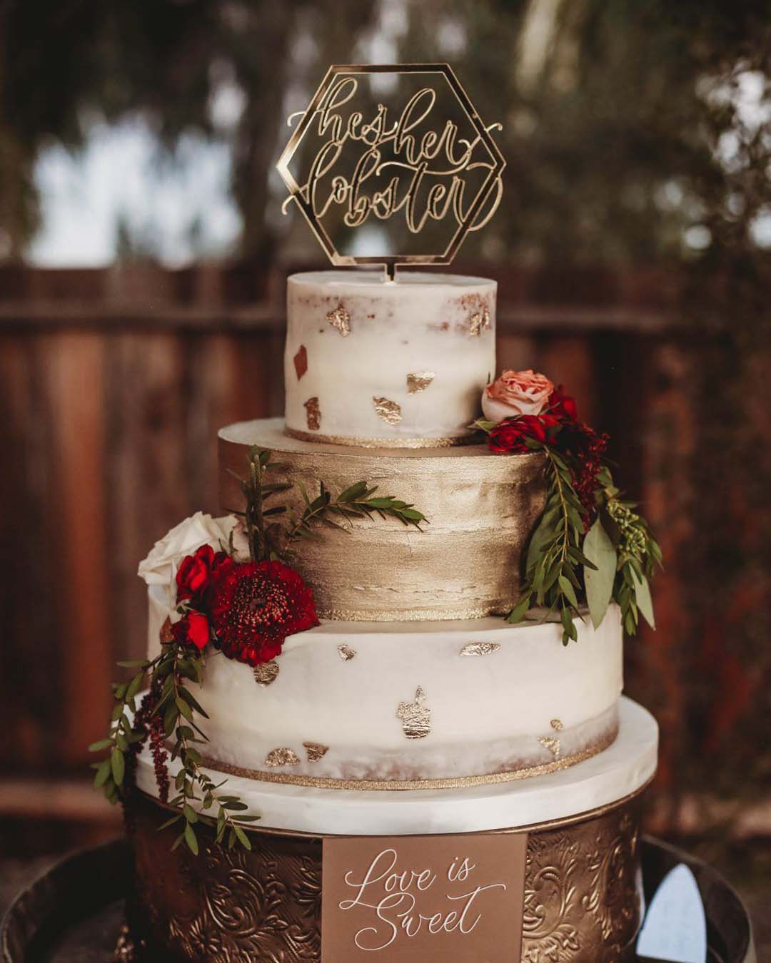 winter wedding cakes elegant with gold foul greens and red flowers malissaqphotography