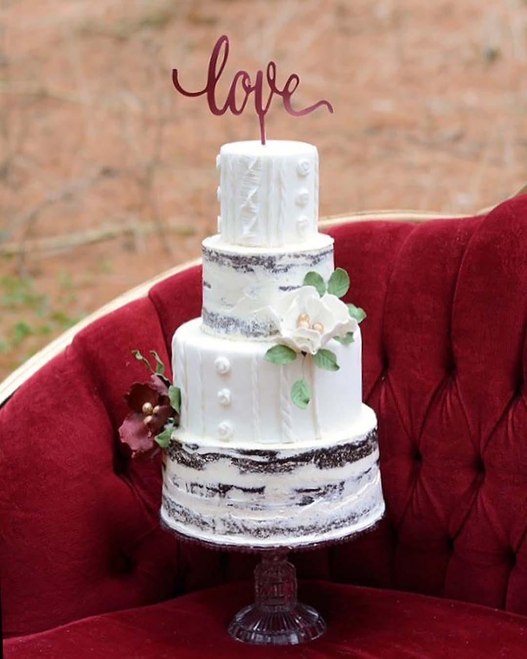 winter wedding cakes white slightly nacked with flowers and love sign topper brighteyescakedesign