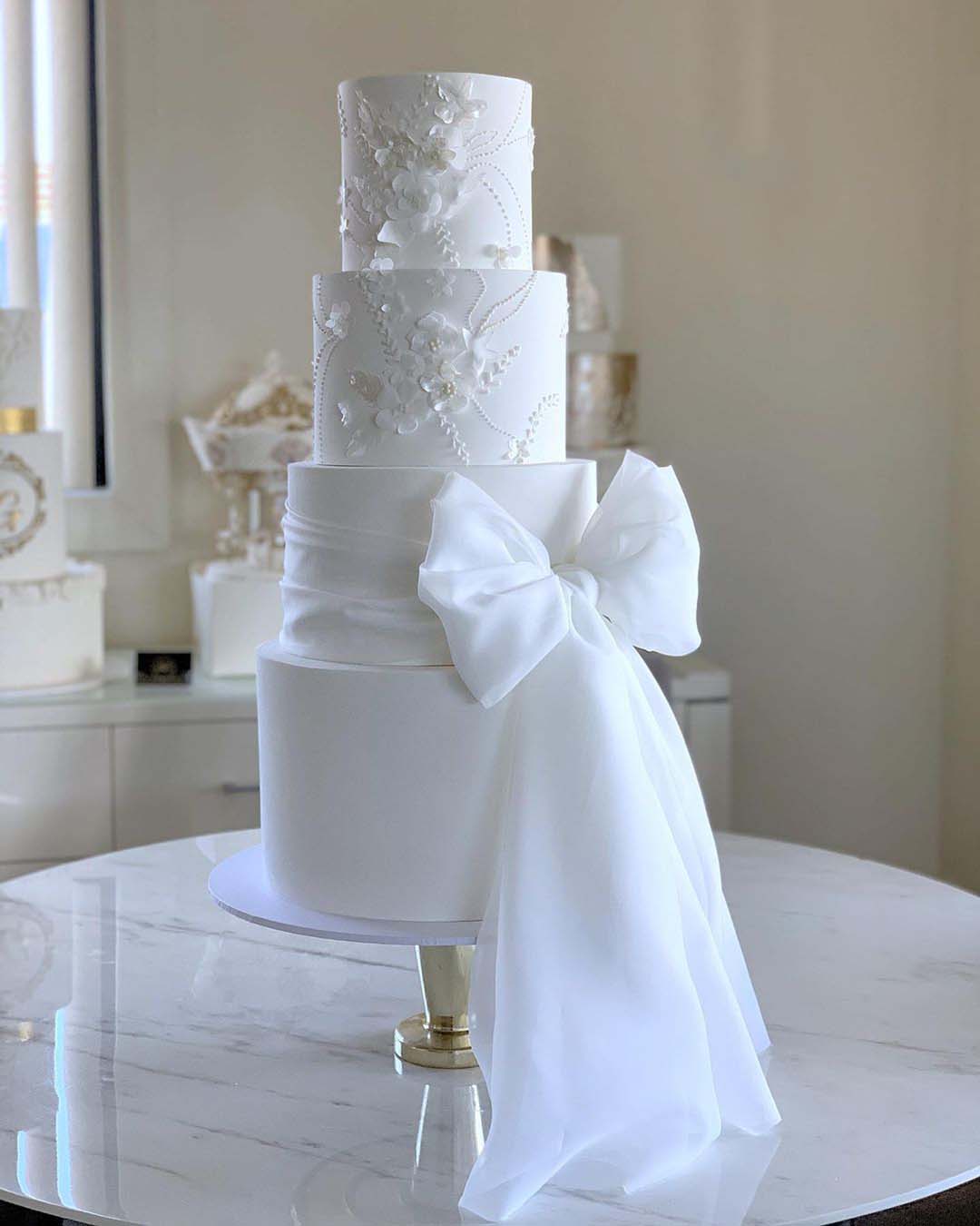wedding cake designers tall white with bow iconic.cake