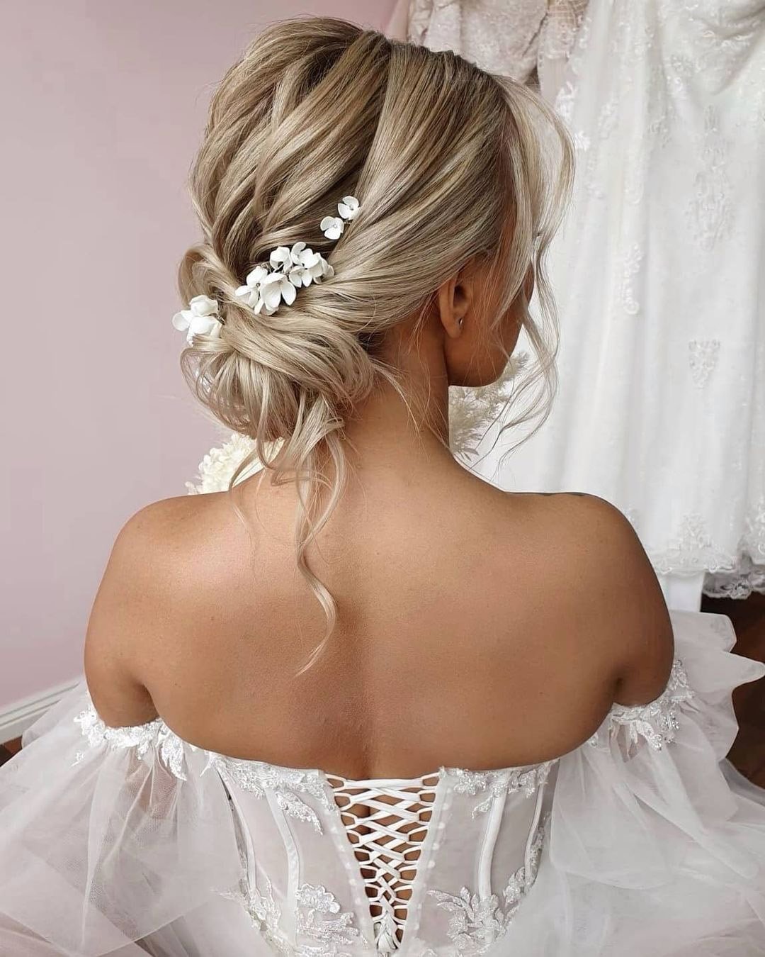 wedding hair trends messy low bun with white flower pin cathughesxo