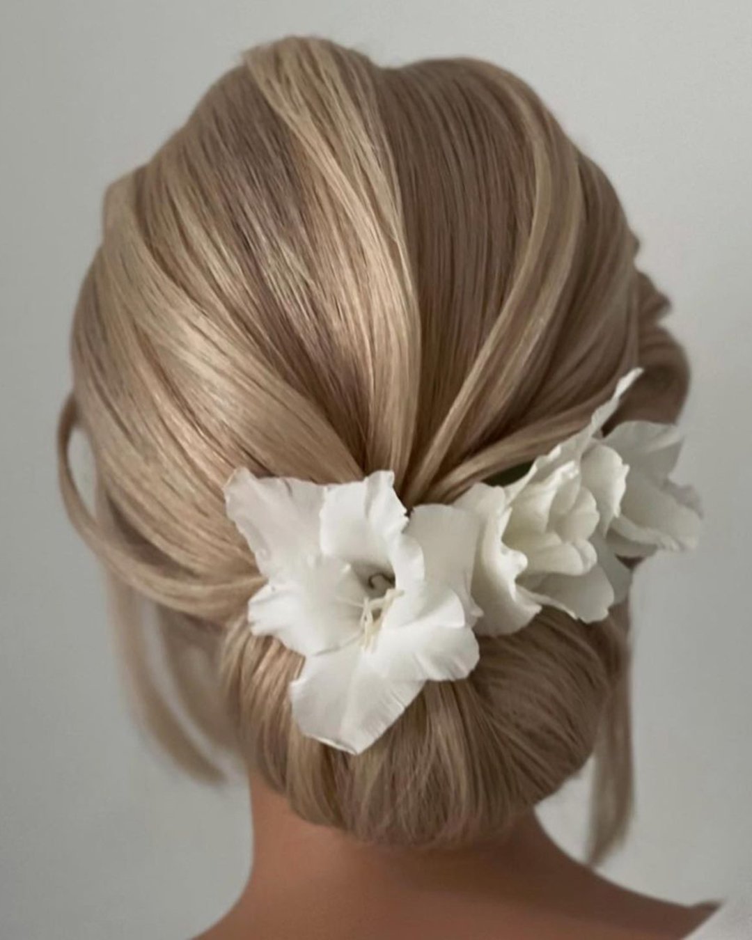wedding guest hairstyles elegant low bun with flowers barbara.szuksztul.lenarczyk