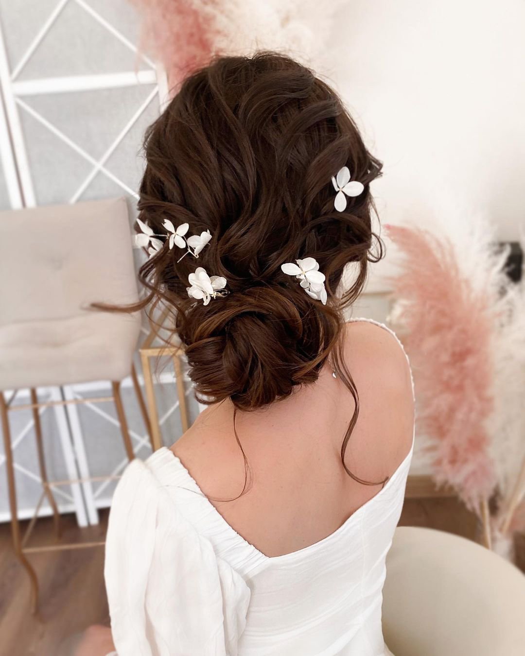 wedding hairstyles for curly hair low bun with flower pins alyona_beauty_muah