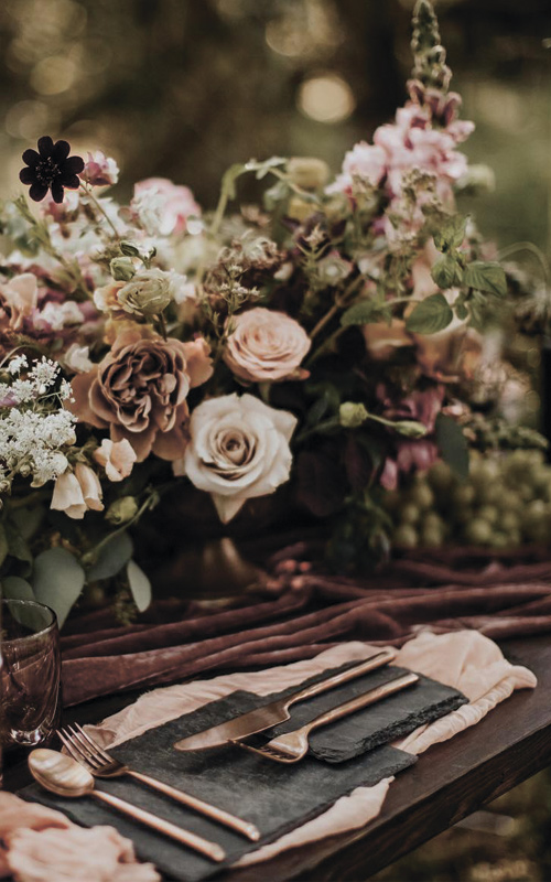 Wildflower nature wedding centerpieces with wood slices, bottles