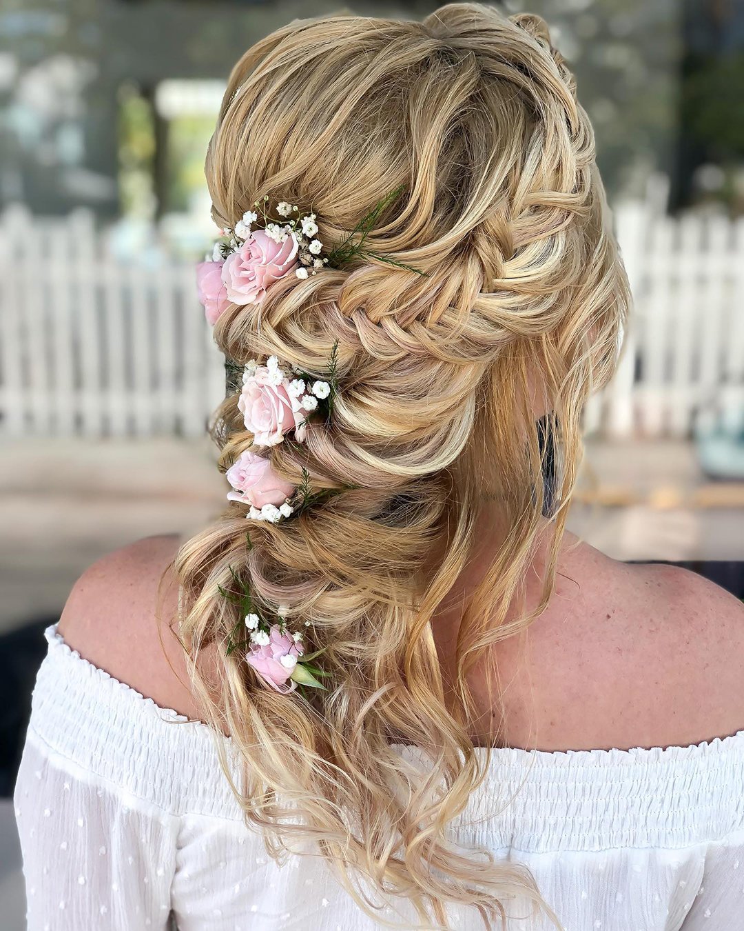 wedding hairstyles with flowers pink roses on messy loose curls reneemarieacademy