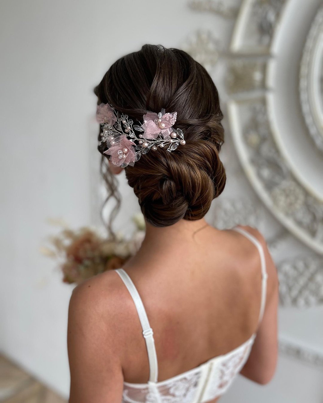 rustic wedding hairstyles low bun with pink flower pin by_telegina