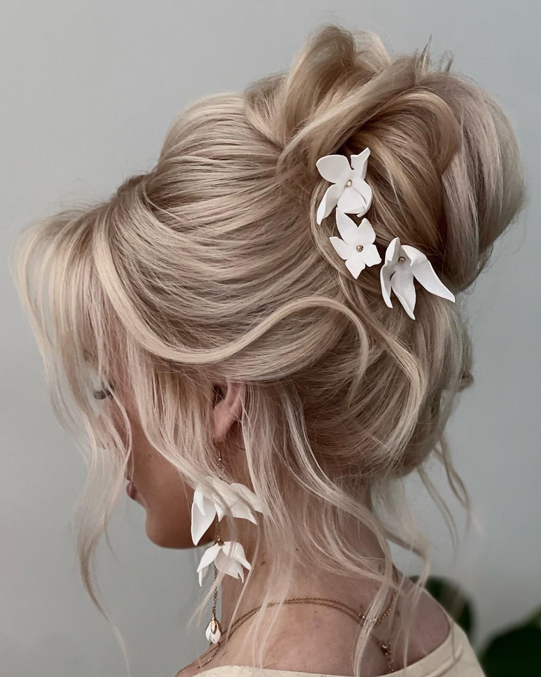 wedding guest hairstyles high textured bun with flowers barbara.szuksztul.lenarczyk