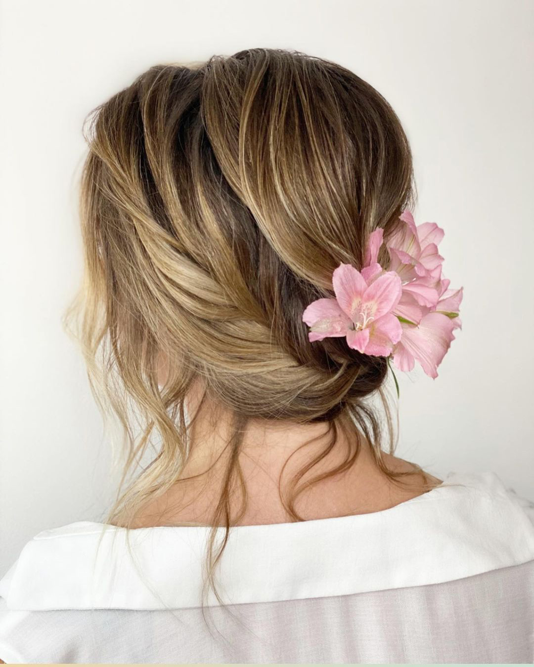 bridal hairpiece messy updo with pink flowers monamieweddinghair