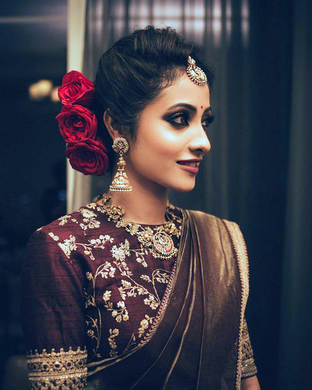 indian wedding hairstyles updo with red roses romaganeshphotography
