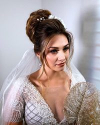 winter wedding hairstyles high bun with veil and white flower pins mateusgibertone